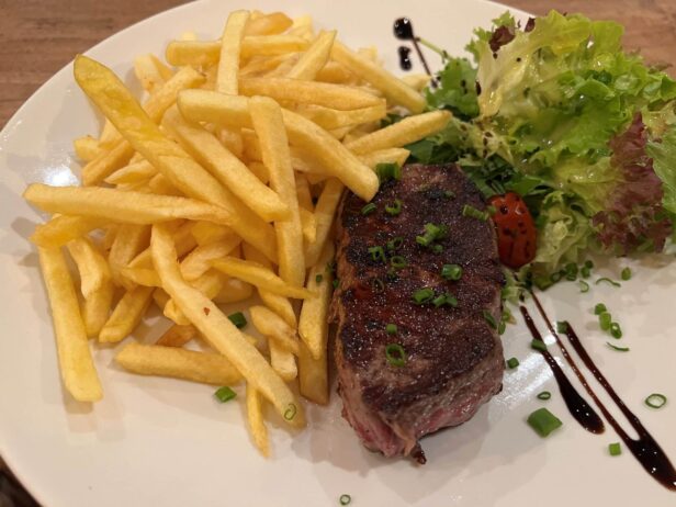 Medium gegartes Steak mit Pommes und Salatbeilage im Restaurant Hammerhütte in Siegen.