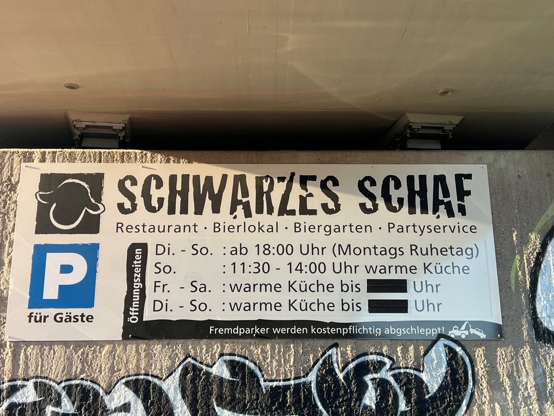 Hinweistafel Öffnungszeiten des Restaurants Schwarzes Schaf in Siegen, mit eigenem Parkplatz vor der Tür.